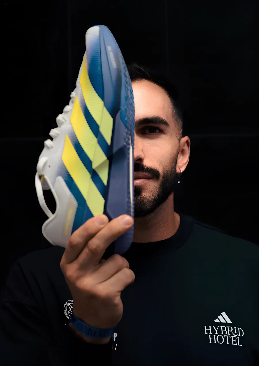 Filipe Prates sujeta una zapatilla de competición que le tapa media cara
